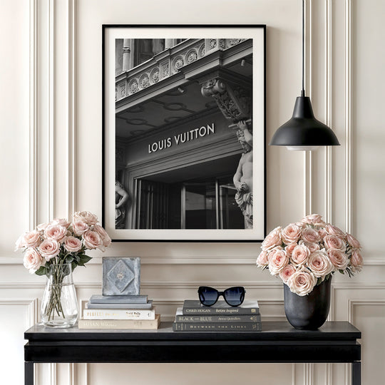Luxury wall art with a black and white photo of a Louis Vuitton boutique and roses in a minimalist interior