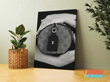 Luxury canvas print with a black and white detail of hands holding a handbag in a modern interior