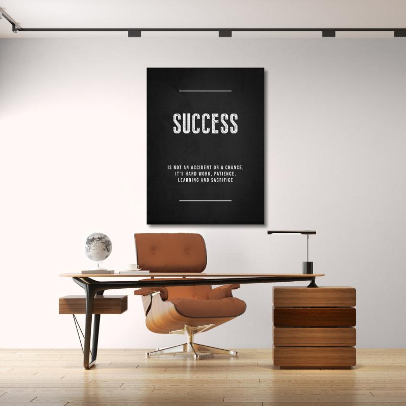 Black and white “Success is not an accident” motivational wall art in a minimalist modern office.