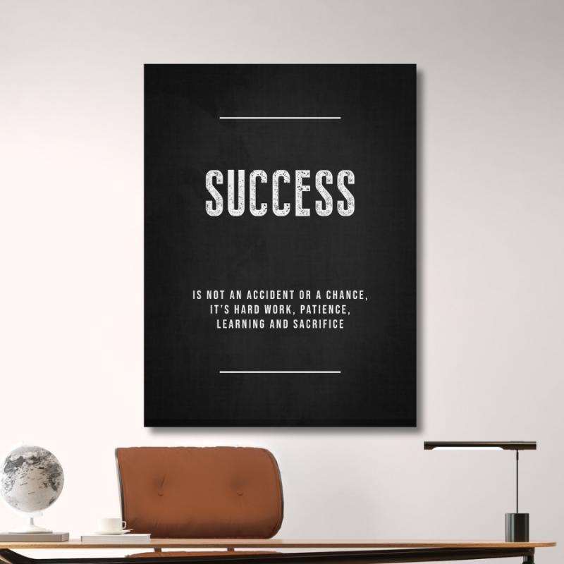 SUCCESS motivational wall art with white typography on a black background in a modern office with a lamp and globe.