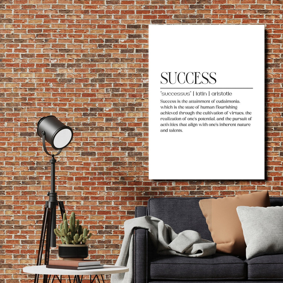 Motivational canvas print with the word Success above a dark blue sofa and lamp on a brick wall