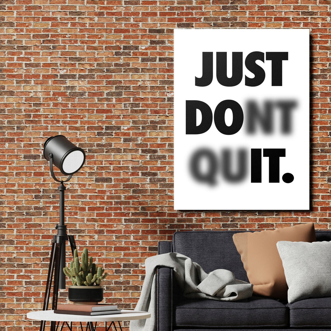 Black and white motivational wall art with a quote on a brick wall beside a metal lamp in a living room