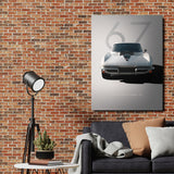Motivational canvas wall art with a Corvette Stingray 427 front view in a minimalist living room with a brick wall