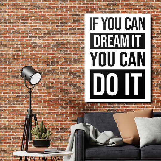 Black and white motivational quote wall art above a sofa beside a brick wall and floor lamp
