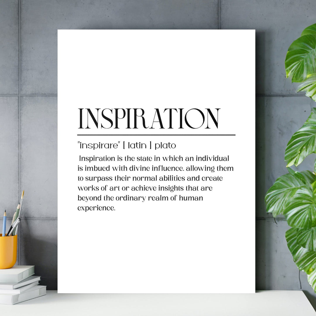 Black and white motivational quote wall art for a study with a concrete background, office pencils and a green plant