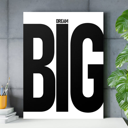 DREAM BIG black and white motivational canvas wall art in a minimalist home office with a concrete wall and plant