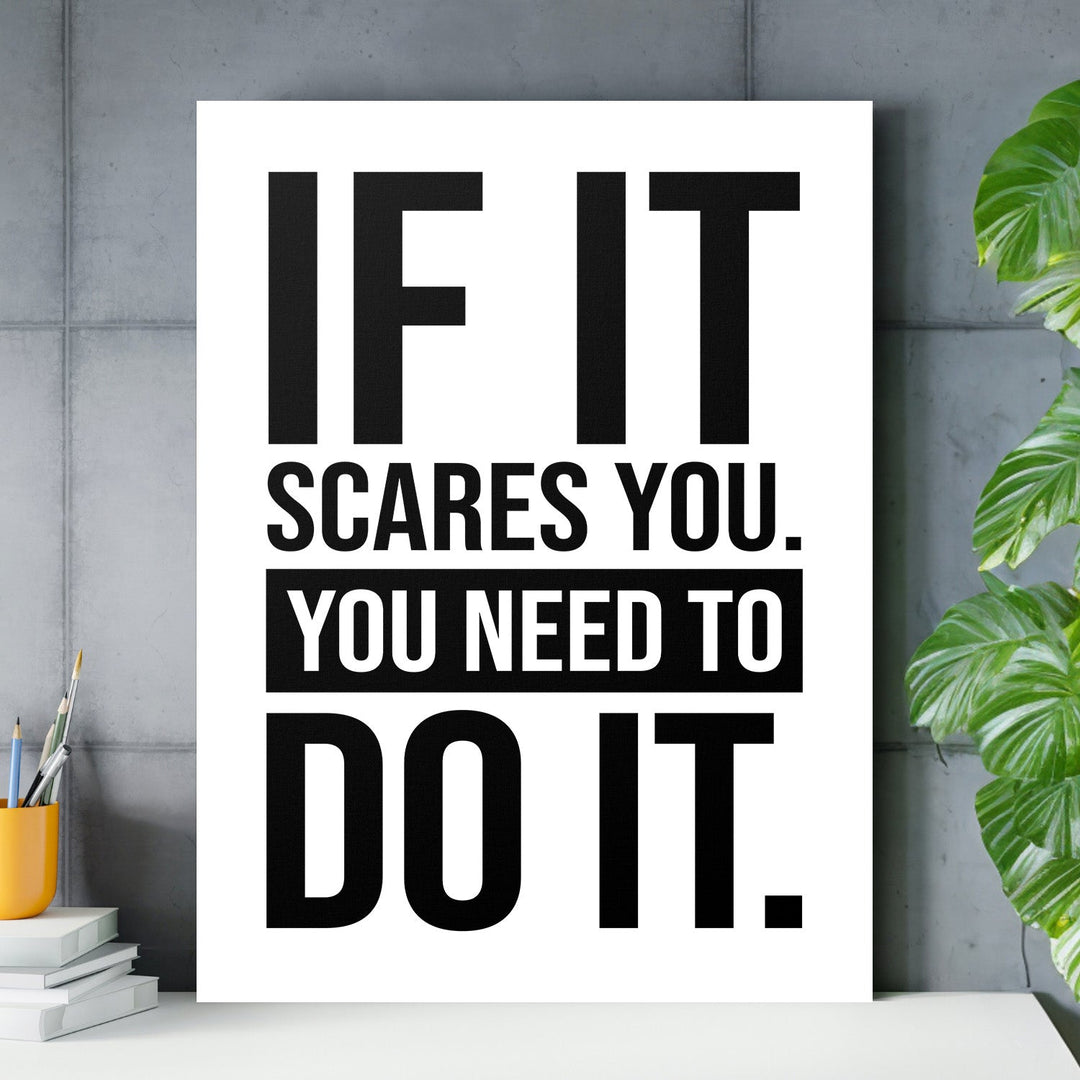 Motivational canvas print with a black-and-white quote in a minimalist office by a concrete wall