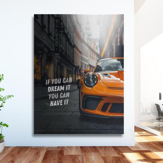 Motivational canvas wall art with an orange Porsche, English quote and urban background in a modern office.