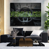 Luxury wall art with a sports car steering wheel and neon "Visualize" text in a modern living room
