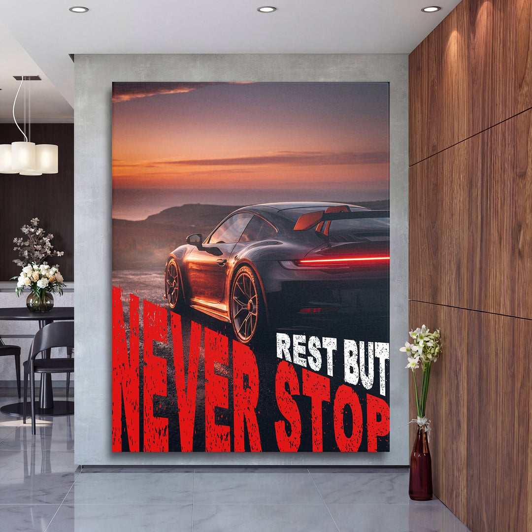 Motivational wall art with a black sports car at sunset and red text in a modern interior