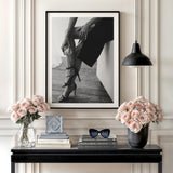Luxury wall art with a black and white photograph of women’s legs in heels and Chanel perfume on a console