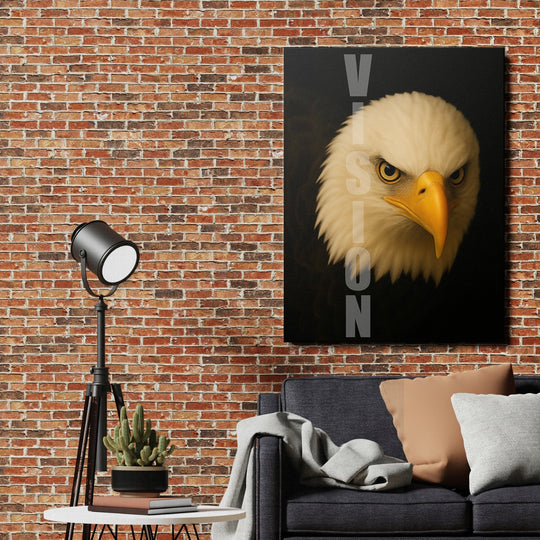 Motivational canvas wall art with a detailed eagle gaze and VISION text hanging above a sofa on a brick wall.