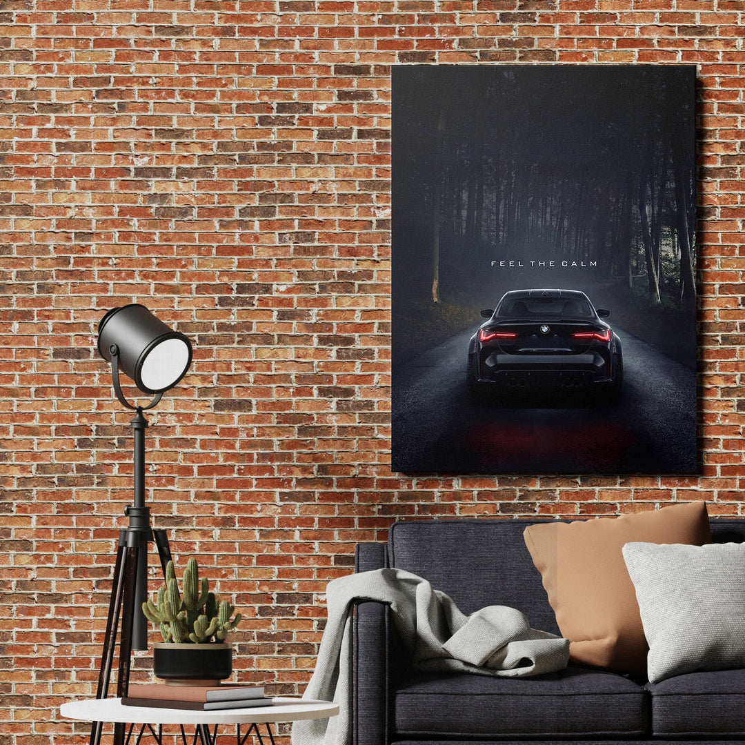 Motivational canvas print with a black BMW on a dark forest road and the quote “Feel the Calm” in a living room