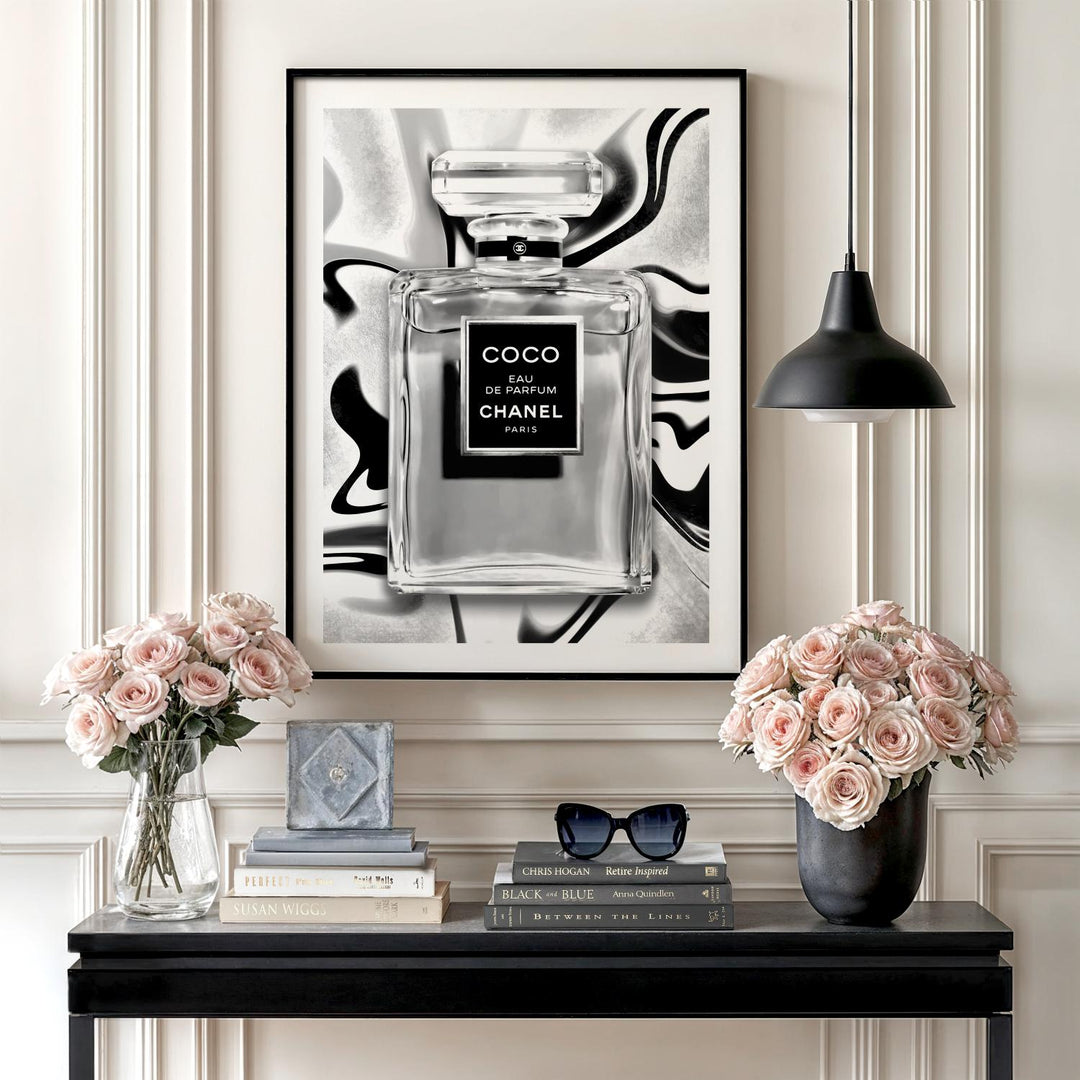 Motivational wall art with a black and white perfume bottle illustration, roses, books and a table lamp in a lifestyle arrangement.
