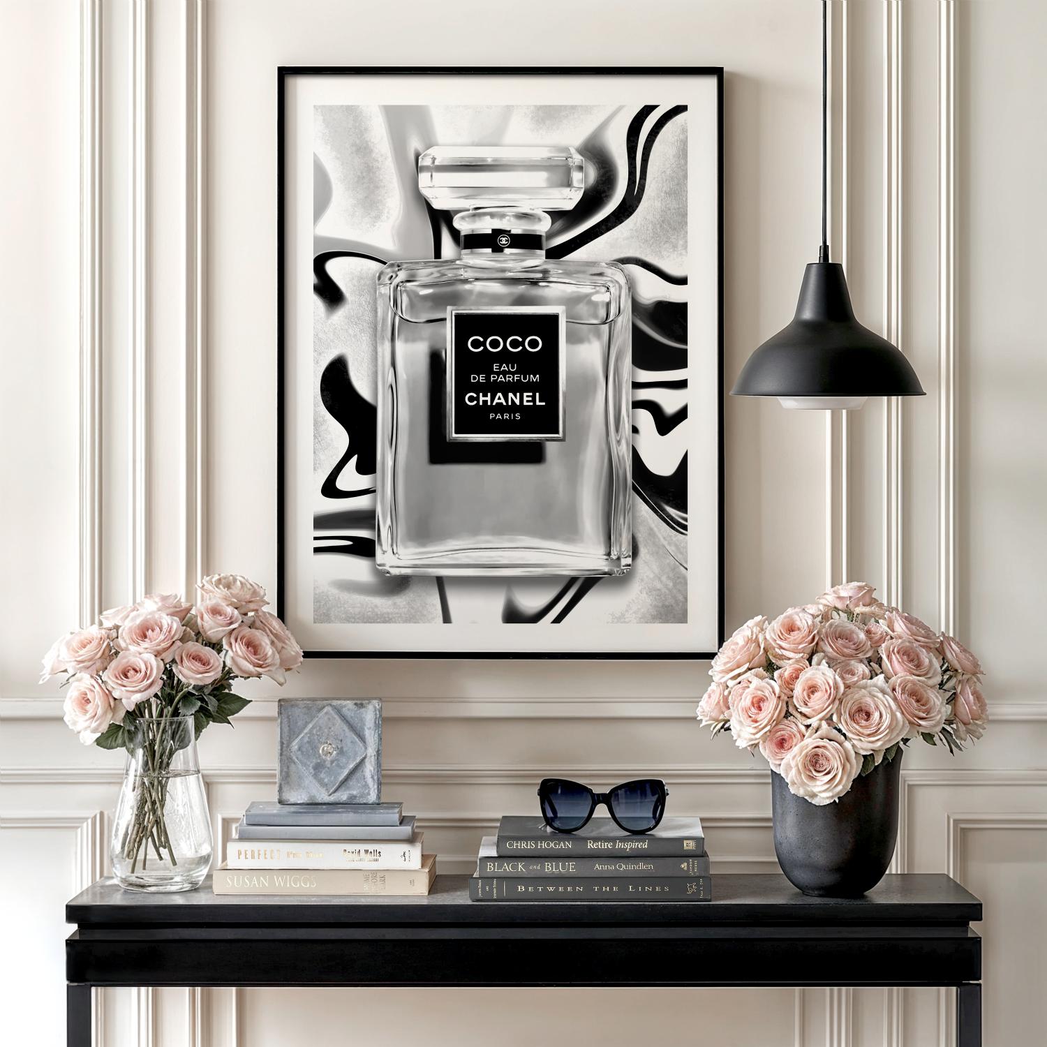 Motivational wall art with a black and white perfume bottle illustration, roses, books and a table lamp in a lifestyle arrangement.