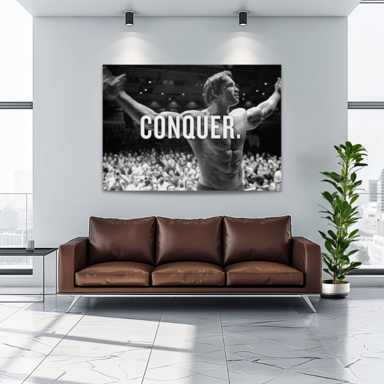 Motivational wall art with Arnold Schwarzenegger, a bodybuilder with outstretched arms and the word CONQUER.