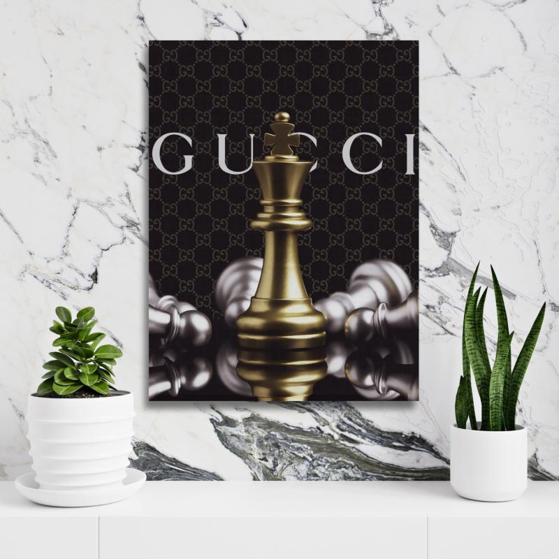 Motivational wall art with a royal chess piece and Gucci-style background on a white wall with a plant.