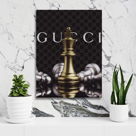 Motivational wall art with a royal chess piece and Gucci-style background on a white wall with a plant.