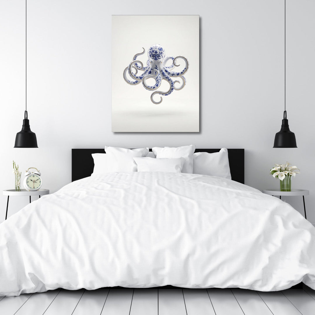 Modern canvas print with a blue-and-white porcelain octopus above a bed in a minimalist bedroom