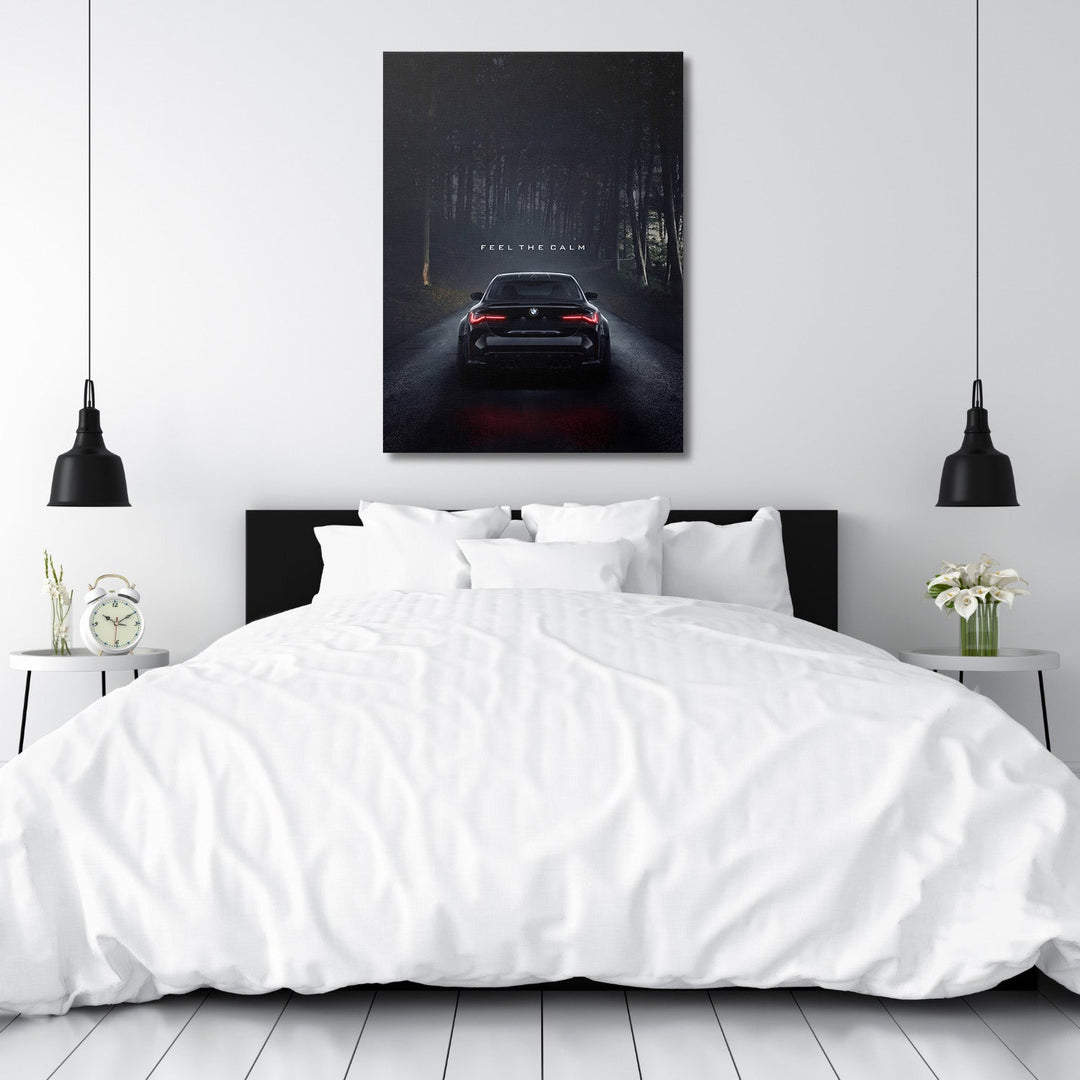 Motivational canvas print above a bed with a black BMW on a night road in a dark forest, automotive lifestyle