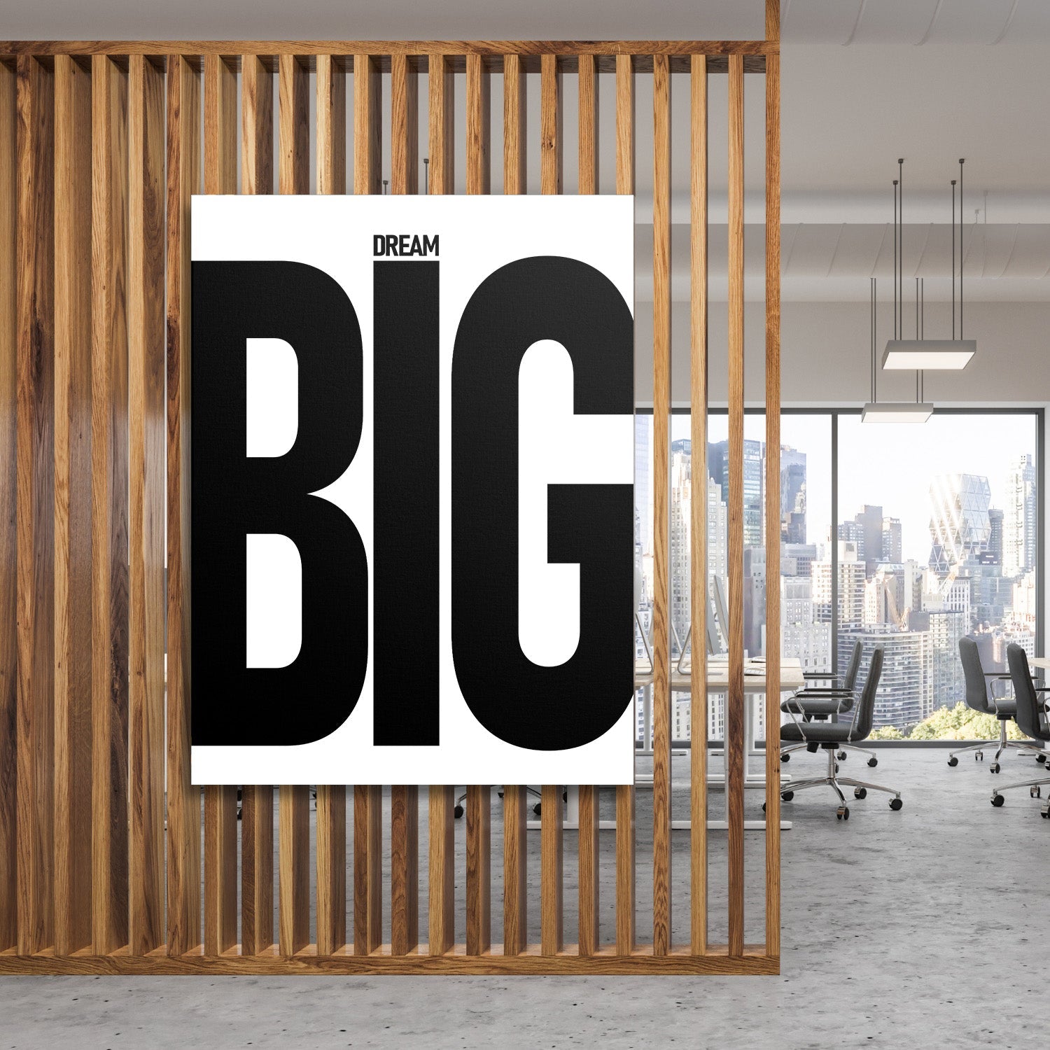 DREAM BIG motivational canvas wall art with black typography in a modern office behind a wooden grid