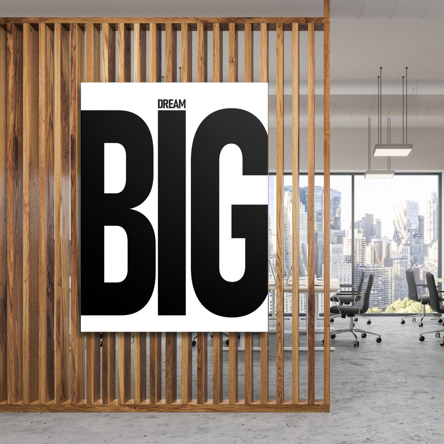 DREAM BIG motivational canvas wall art with black typography in a modern office behind a wooden grid