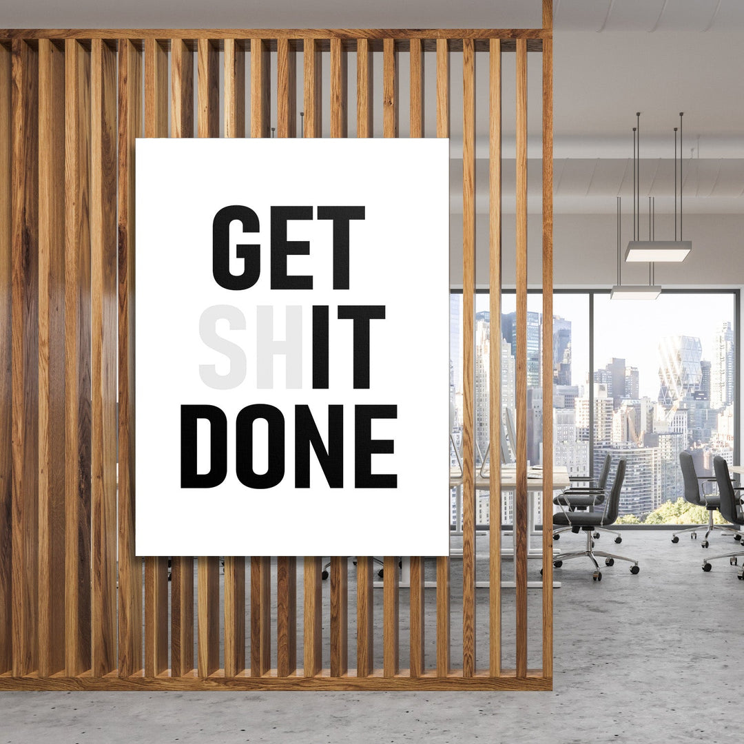 GET SHIT DONE motivational canvas wall art hanging behind wooden slats in a modern office