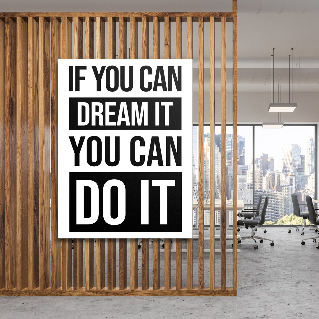 Motivational canvas wall art with a black and white quote in a minimalist modern office