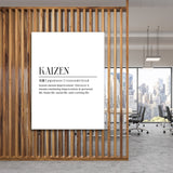 Kaizen motivational canvas wall art hanging on a wooden partition in an office with a city skyline view