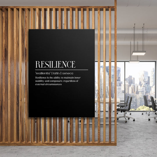 Motivational canvas print with a Latin quote about resilience, hanging on a wooden wall in a modern office