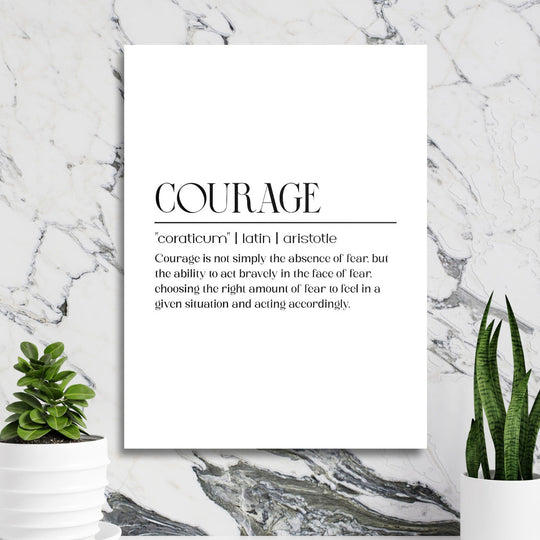 Motivational wall art with a “Courage” quote in a minimalist interior with a marble wall and green houseplants