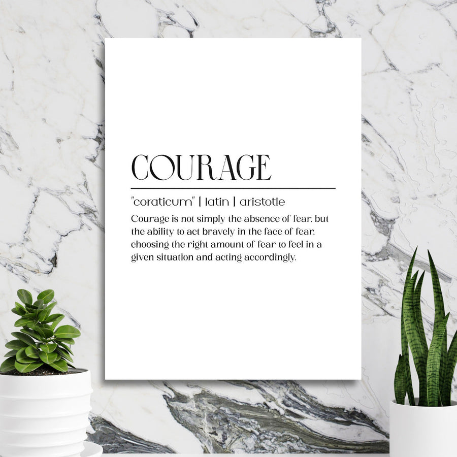 Motivational wall art with a “Courage” quote in a minimalist interior with a marble wall and green houseplants