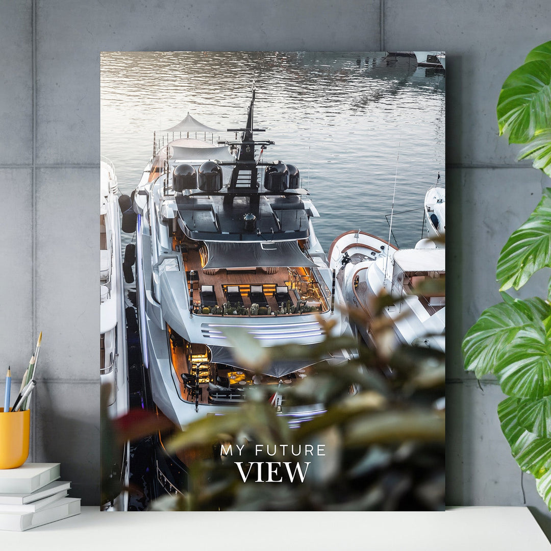 Motivational canvas print with a luxury yacht in a marina and the text “My Future View” on a concrete wall above a side table