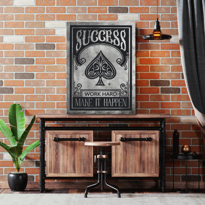 Motivational canvas wall art with a spade symbol and “Success, Work Hard, Make It Happen” quote in an industrial interior.