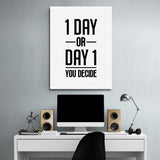 “1 Day or Day 1” motivational wall art above a desk with a monitor, lamp and wooden speakers.