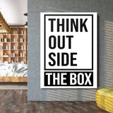 Black and white “Think Outside the Box” motivational canvas wall art above a bed in a modern bedroom
