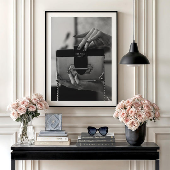 Modern wall art with a black and white photograph of hands holding a handbag in an elegant interior