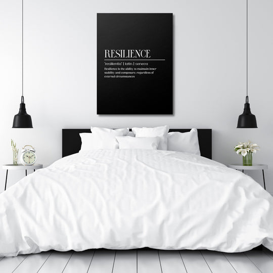 Motivational canvas print with a Resilience quote hanging above a white bed in a minimalist bedroom