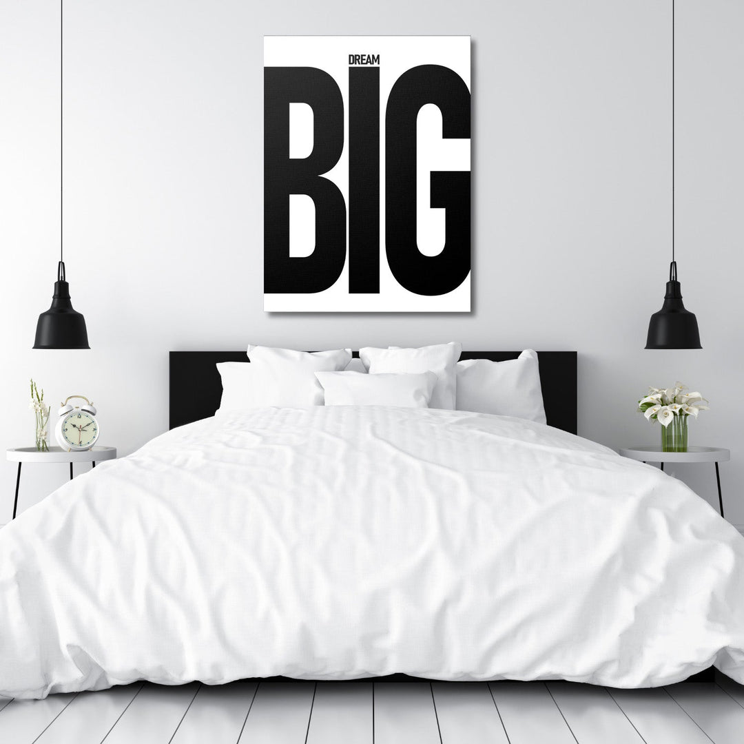 DREAM BIG black and white motivational canvas wall art above a white bed in a minimalist bedroom