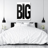 DREAM BIG black and white motivational canvas wall art above a white bed in a minimalist bedroom