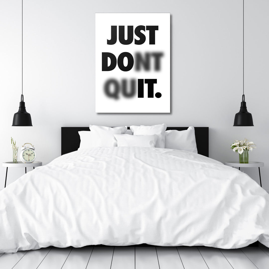 Black and white motivational quote wall art above a bed in a minimalist bedroom