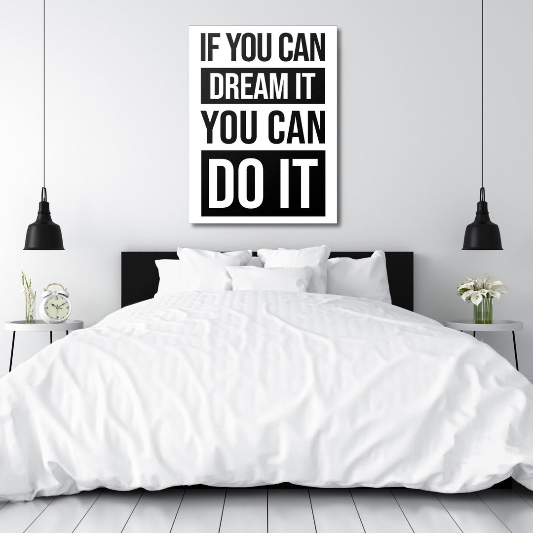 Black and white motivational quote canvas wall art above a bed in a minimalist modern bedroom