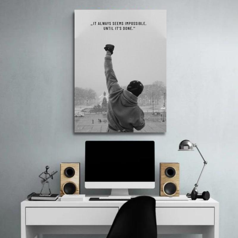 Motivational wall art above a desk with a black and white boxing stance and an inspirational quote.