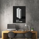 Office motivational wall art with a 3D “DO IT DO IT NOW” quote above a work desk.