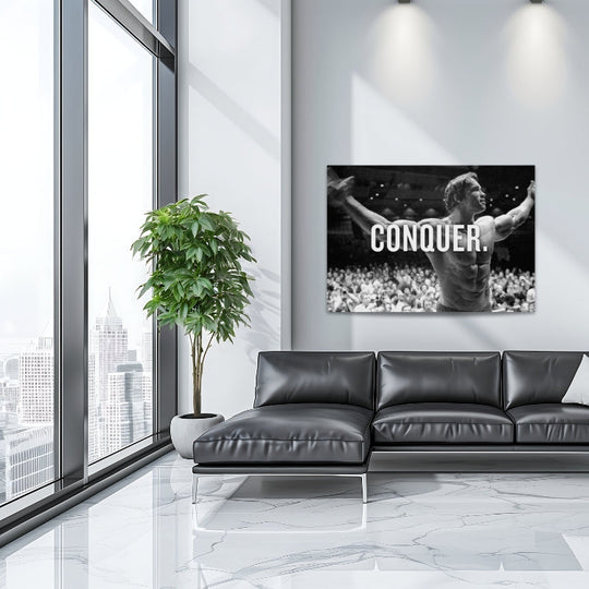 Motivational wall art with a black and white bodybuilder raising his arms and CONQUER text in a modern living room.