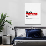 “Don’t Overthink It” motivational canvas wall art above a bed in a modern minimalist bedroom.